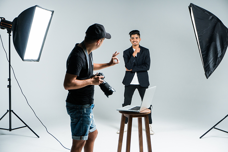 Professional photographer taking photos of indian model in studio with leight